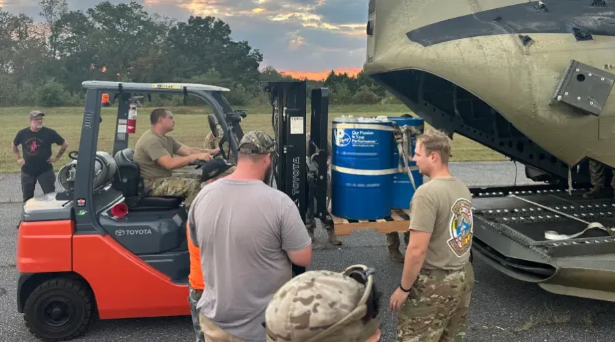 men loading supplies to helicopter